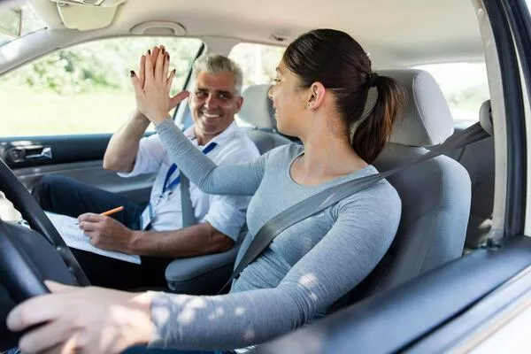 Learning from an expert might actually be better than having to learn by yourself. Woman taking driving lessons