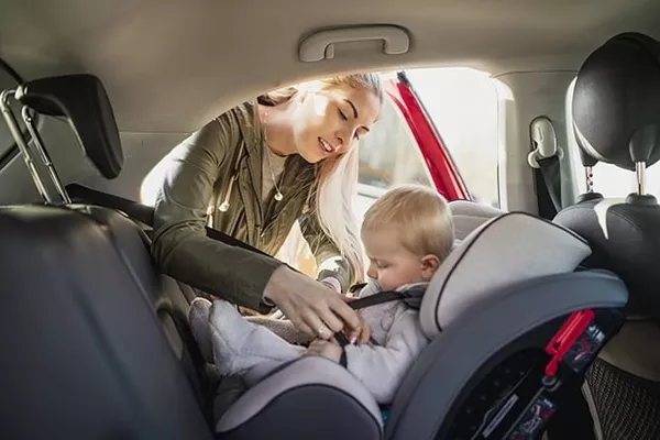 Mother fixing the baby car seat