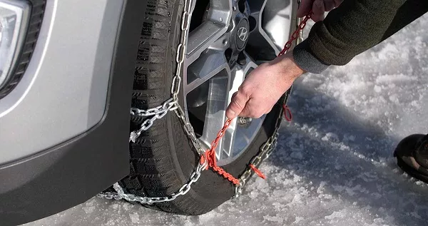 Your tire chain can come in a variety of ways to tighten it Man tightening tire chain