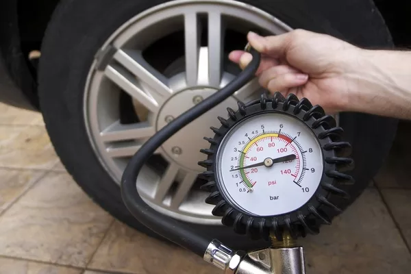 A man using tire pressure gauge