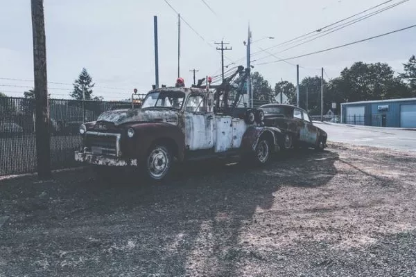 A classic tow truck towing a car