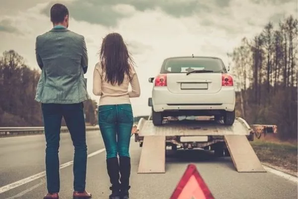 A couple getting their car towed
