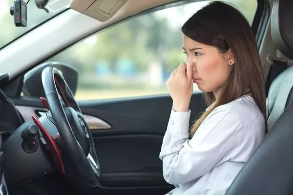 Bad transmission fluids can produce a burned smell A woman inside a car