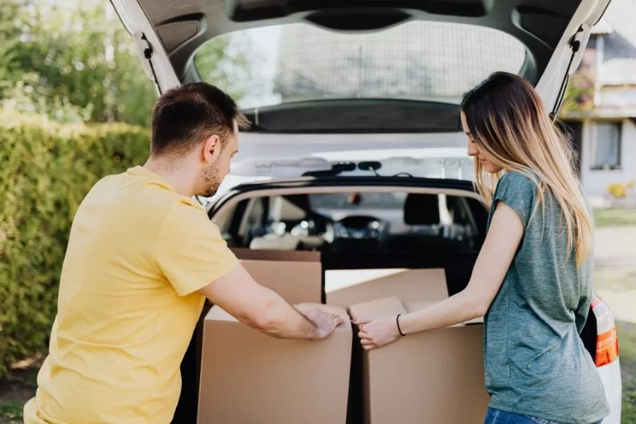 Couple loading boxes in car