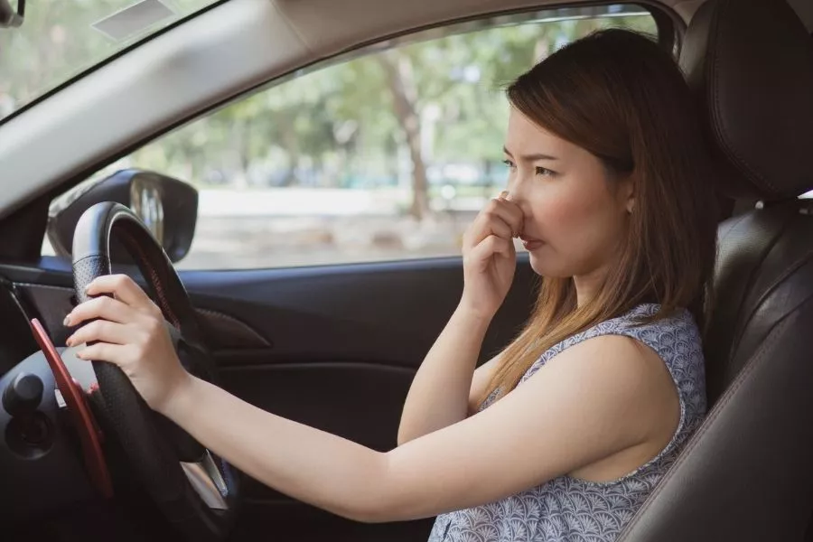 Lady in car covering nose