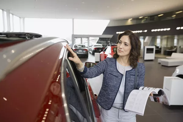 Take note that even if the car is already a year or two years old, you should still be able to use it for years to come Woman checking the car