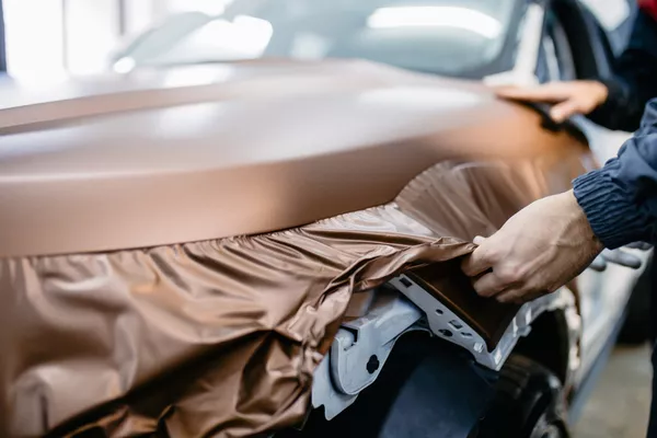 Man putting vinyl wrapping in the car