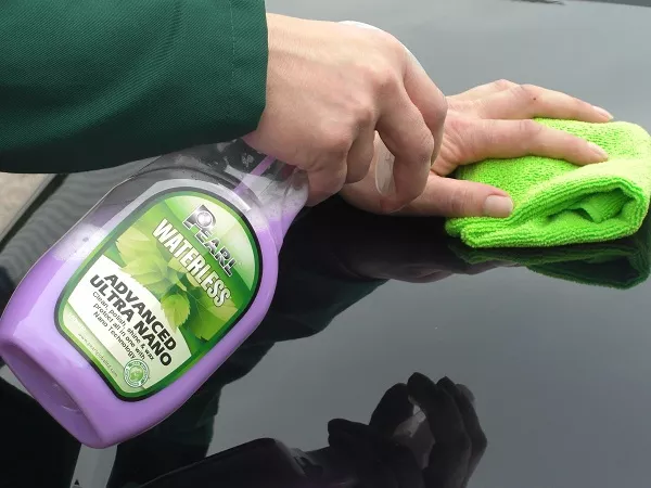 Man holding cleaning spray and microfiber towel