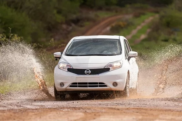 White Nissan car driving in the mud