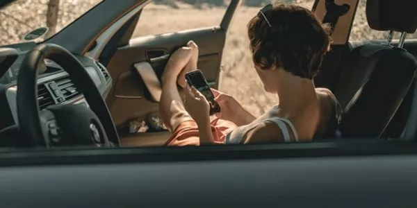 girl using phone on car