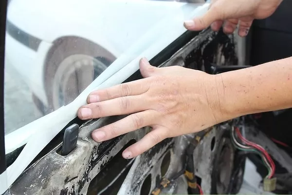 spot the area around it for leaks or cracks that could be causing the inconvenience. Man checking the car door