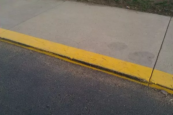 A picture of a curb painted yellow