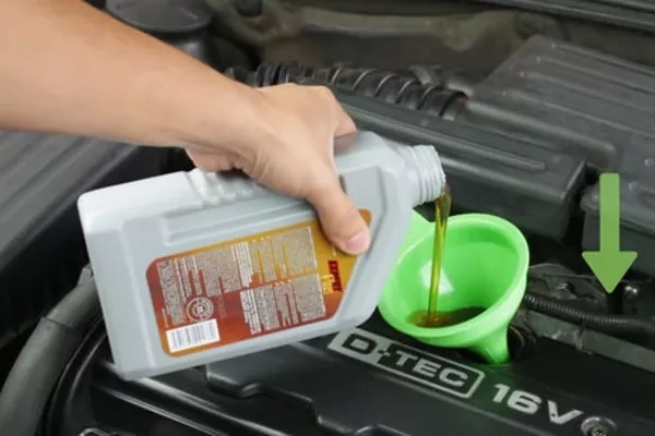 man putting engine oil in the car 