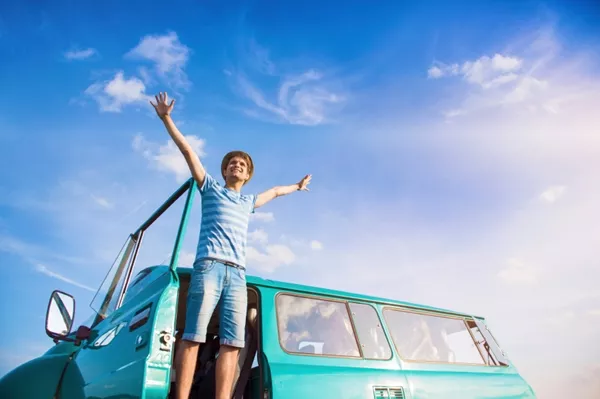 young people hands in the air with a car