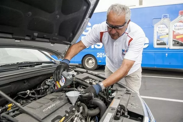 man changing car engine oil