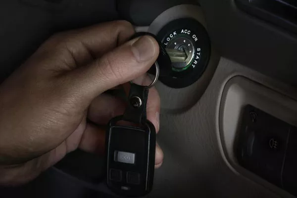 A photo of man trying to start up his car