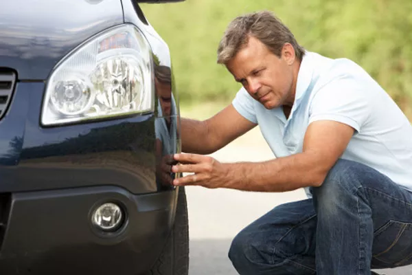 a man checking his car's tires