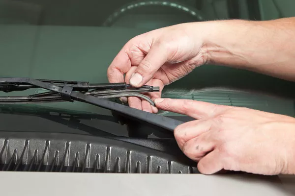 a man checking his car's wiper blades