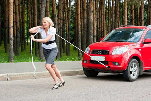 A woman towing a car
