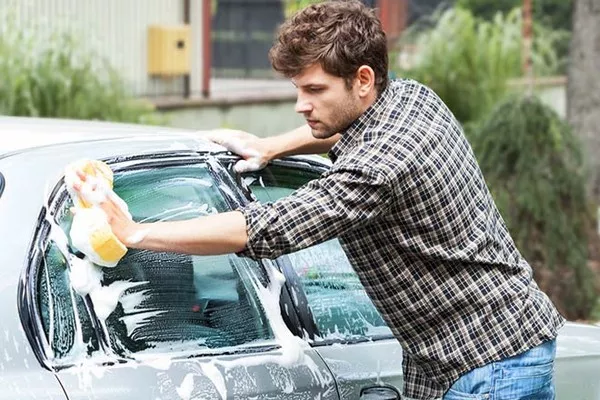 a man washing his car exterior