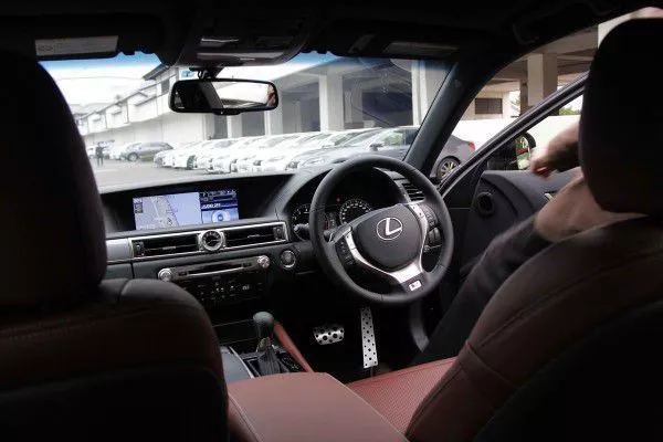 A driver getting out from a right-side driving Lexus