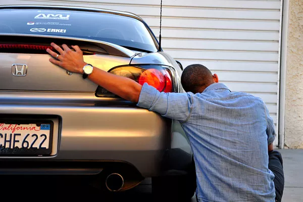 A man hugging his car