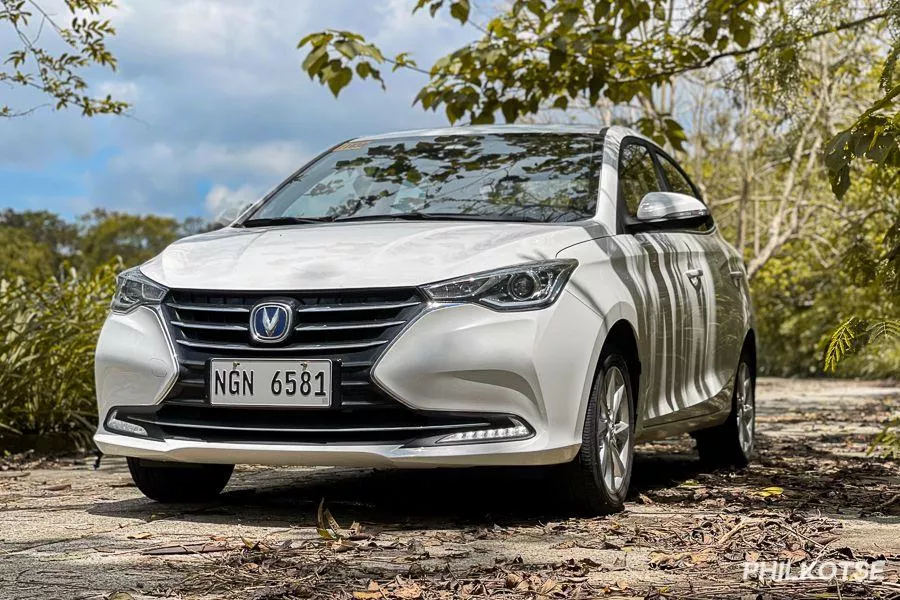 A picture of a Changan Alsvin parked near some trees