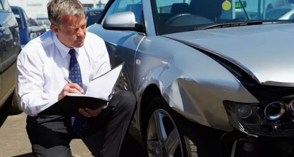 A man is checking the car.
