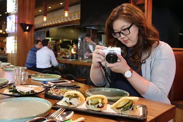 a woman taking photo of dishes