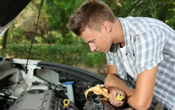 young man checking car engine outdoor