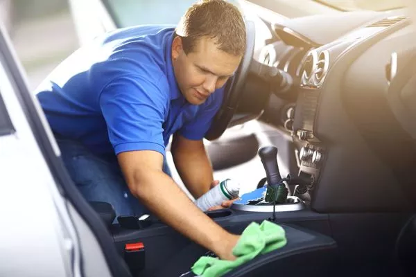 a man cleaning upholstery in a car
