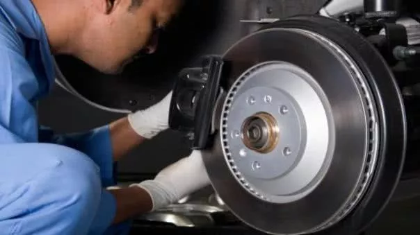 A man is checking car brake