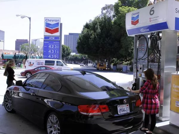 a girl filling gas at gas station