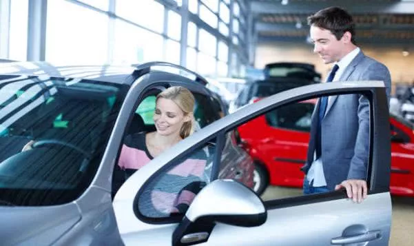 A saleman guiding his customer to test a car