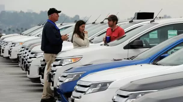 car seller and buyers discussing at a car park