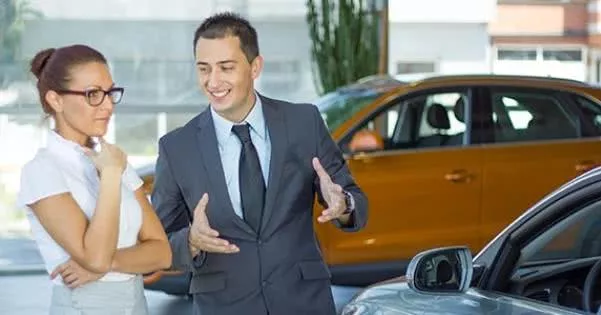 A car salesman introducing cars for his customer