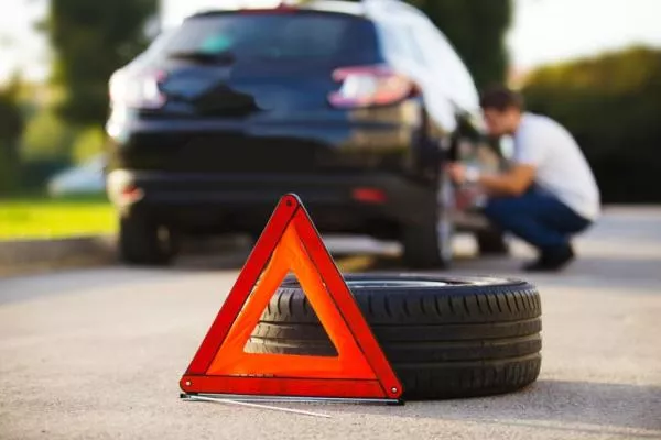There are many causes of tire damage and tire explosion a man changing car tire on the roadside