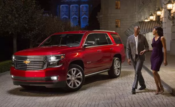 A red Chevrolet Tahoe and a couple