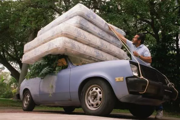 a man loading unnecessary items on a car