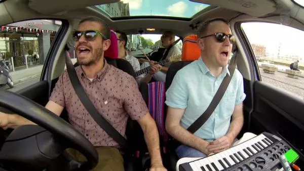 a family playing instrument and singing in car