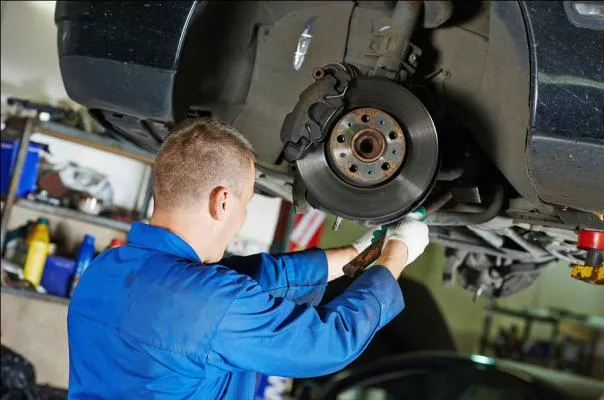 A mechanic is inspecting a car