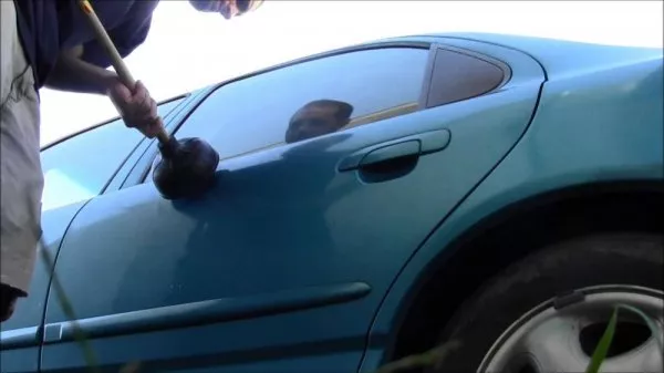 Use a plunger with a vacuum to clean dents out A men uses a plunger to clean dents out