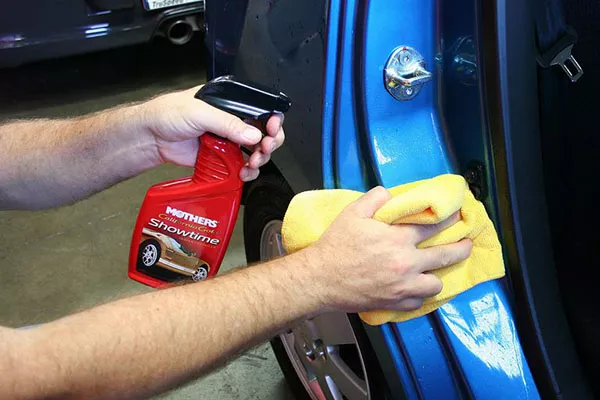 Using a microfiber cloth to wipe the car