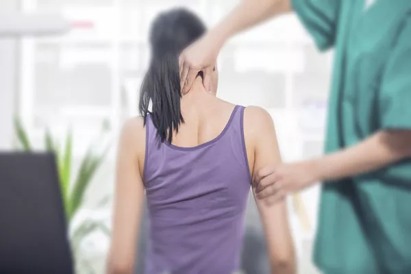 A doctor checking a woman's neck