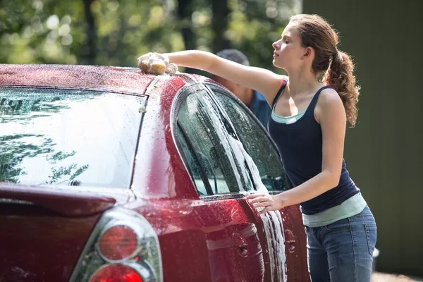 a woman washing her car