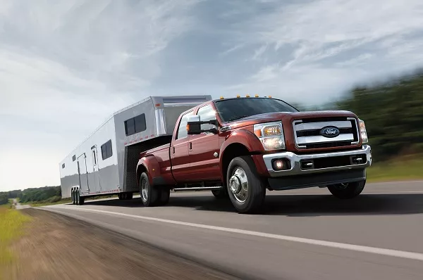 a Ford pickup truck towing a car