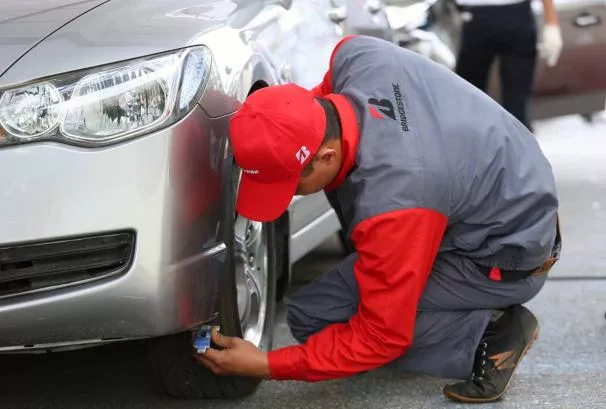 A car mechanic checking a car tire