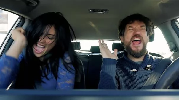 A man and woman dancing in a car