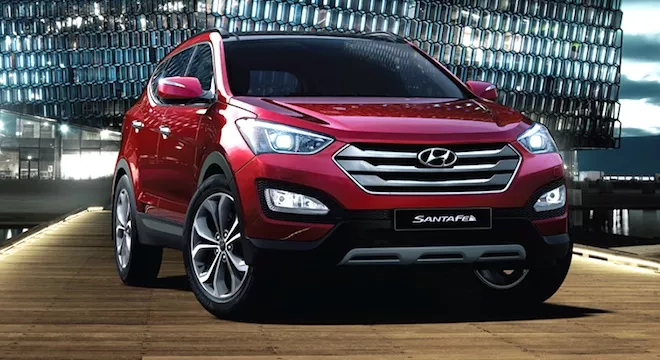 A red Hyundai Santa Fe angular front view