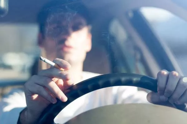 A man smoking in car while driving